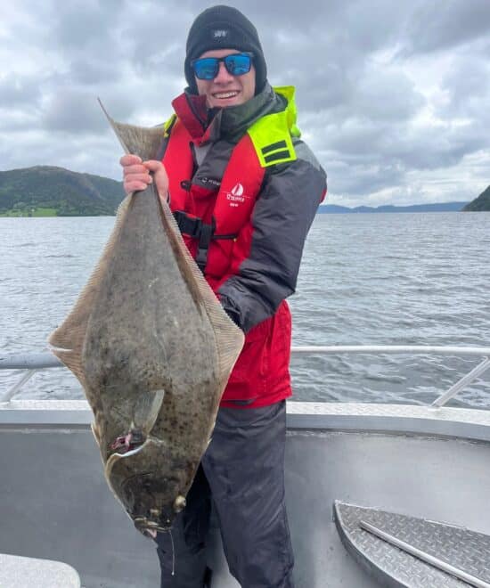 Angler mit kapitelem Heilbutt auf dem Boot